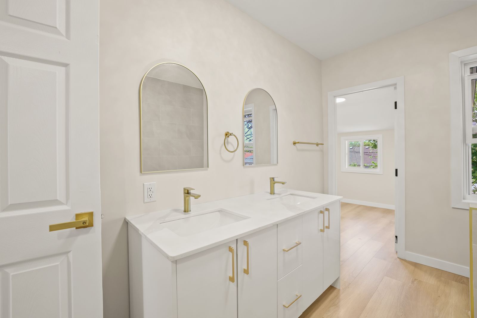 Main bathroom with double vanity and arched mirrors